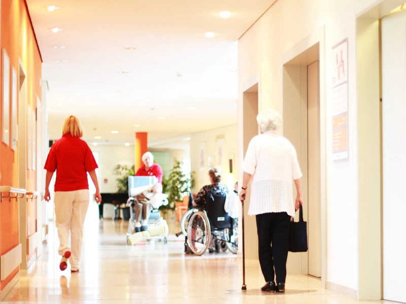 Corridor in a healthcare facility with elderly people walking