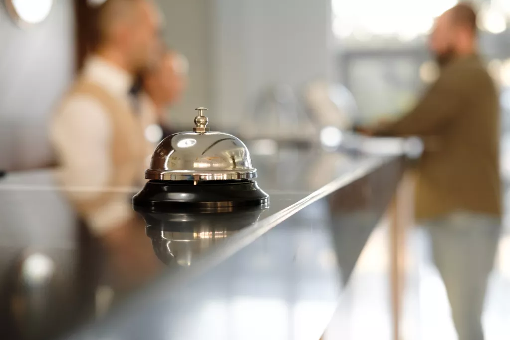 Close up of silver bell on hotel reception desk.